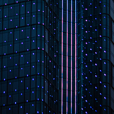 Nahaufnahme eines gläsernen Bürogebäudes bei Nacht